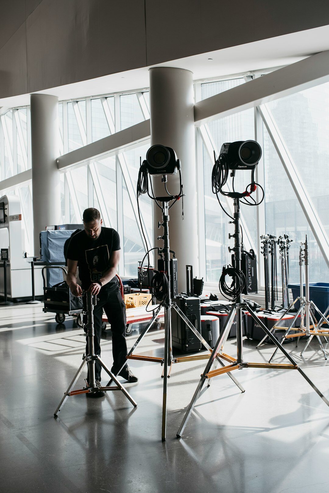 Technician adjusting studio light fixture on a truss